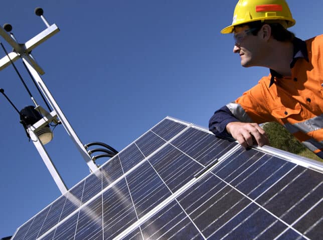 Man in hard hat with solar panel and communication device