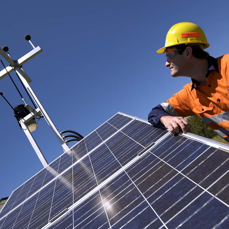 Man in hard hat with solar panel and communication device