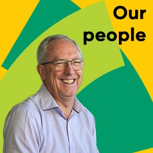man smiling in front of the words 'our people'