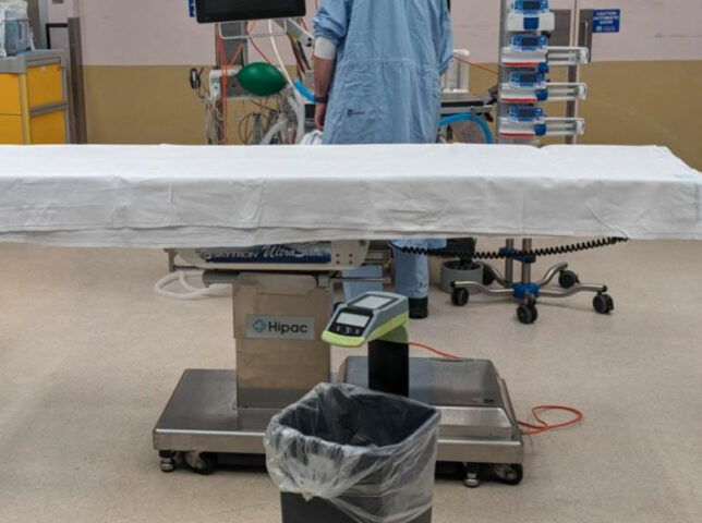 Person in surgical scrubs in operating theatre with SureWaste system.
