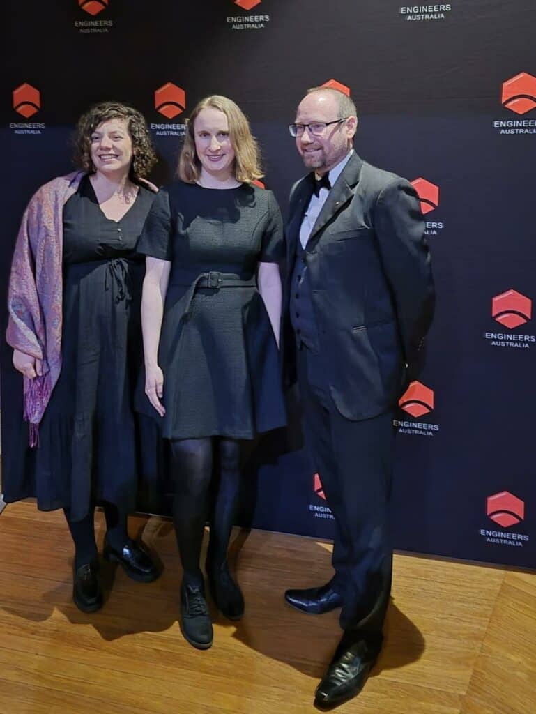 Three professionals at Emergent Group recognition event in Australia.